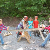 Bild vergrößern: Kinder beim Brennholzsägen